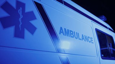Logolu acil durum arabası yaklaşıyor. Amblemli ambulans aracı