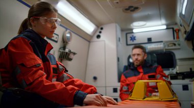 Acil yardım ekipleri acil durum arabasında trafik kazası için acele ediyorlar.