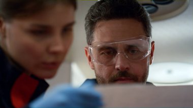 Hasta elektrokardiyogramında sinüs kalp ritmini kontrol eden ambulans doktorları.