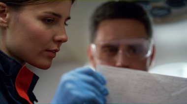 Kağıt üzerinde elektrokardiyogram grafiklerine bakan ciddi sağlık görevlilerinin portresi