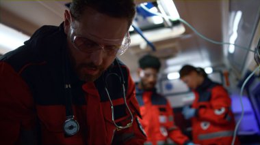 Acil serviste çalışan bir doktor. Ambulans ekibi acil çağrı için hareket ediyor.