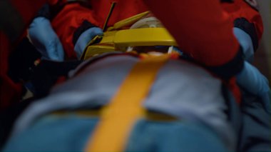 Tanımlanamayan sağlık görevlileri acil durum aracında sedyeyle hastayı kurtarıyor..