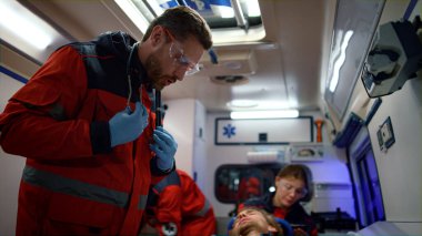 Paramedikler acil serviste hastayı sedyeyle muayene ediyor.