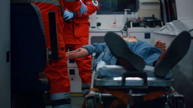 Acil yardım ekipleri acil durum arabasındaki yaralıyı tedavi ediyor.