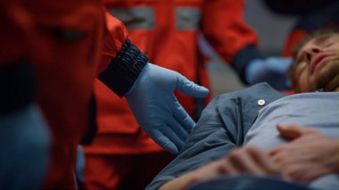 Hasta ambulans arabasında sedyelerin üzerinde yatıyor. Yorgun adamın midesi ağrıyor.