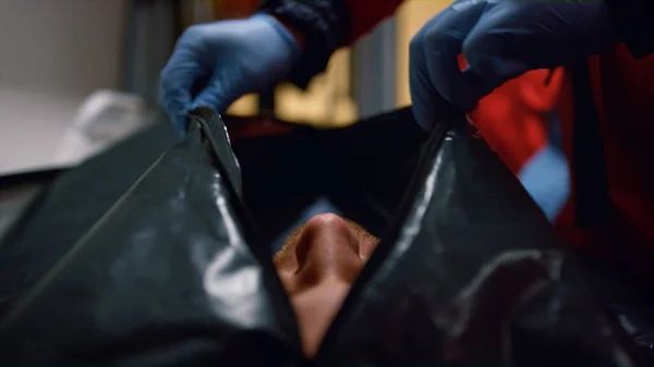 Mãos paramédicas de close-up fechando o saco do corpo com o homem morto após a doença coronavírus — Fotografia de Stock