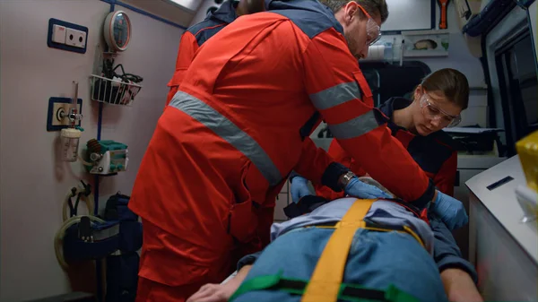 Ratownicy medyczni udzielający pierwszej pomocy poszkodowanemu w wagonie ratunkowym — Zdjęcie stockowe