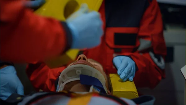 Paramédicos realizando primeros auxilios del paciente en coche de emergencia —  Fotos de Stock