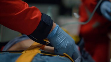 Doktor elleri steteskopla adamı muayene ediyor. Sağlık görevlileri ilk yardım sağlıyor.