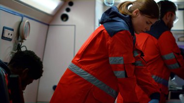 Doktorlar ambulanstaki adama kalp masajı yapıyor. Kalp masajı yapan sağlık görevlileri