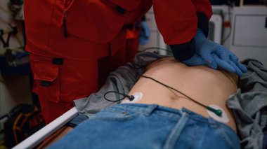 Sağlık görevlileri acil durum arabasında sedyeyle yaralı adama kalp masajı yapıyor.