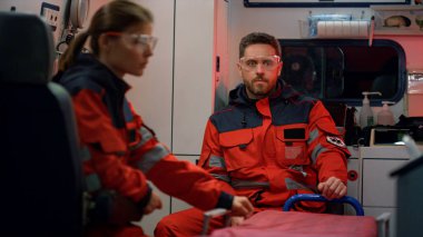 Ambulans ekibi trafik kazasına gidiyor. Sağlık görevlileri sedye hazırlıyor.