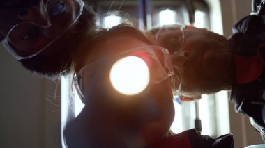 Çok ırklı sağlık görevlileri ambulans arabasında fenerle hastayı inceliyor.