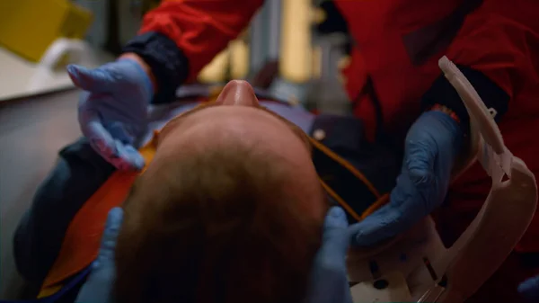 Team van paramedici in handschoenen die de EHBO-procedure in een noodvoertuig uitvoeren — Stockfoto