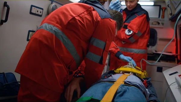 Los paramédicos rescatan al paciente en ambulancia. Equipo médico que proporciona ayuda de primeros auxilios —  Fotos de Stock