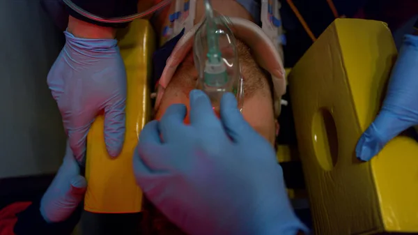 I paramedici nei guanti che forniscono aiuto ambulanza all'uomo. Vittima in maschera di ossigeno — Foto Stock