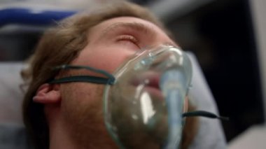 Coronavirus hastası ambulansta sedyede yatıyor. Paramedikler ilk yardım yapıyor 