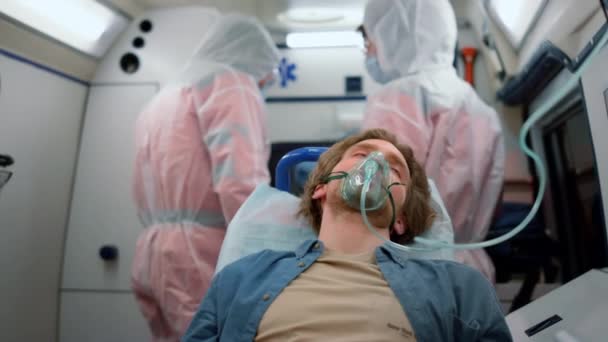 Oksijen maskeli erkek hasta acil durum arabasıyla hastaneye gidiyor. — Stok video