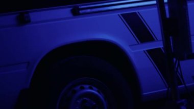 Amblemli ambulans arabası. Karanlıkta kırmızı ve mavi ışıklar yanıp sönüyor.