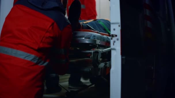 Médicos de emergencia trasladando al paciente en camillas al coche de emergencia — Vídeos de Stock