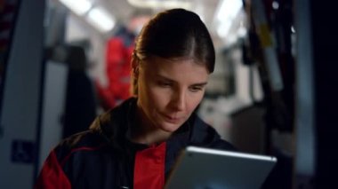 Paramedikler tablet bilgisayarda çalışıyor. Sosyal medya ağında sörf yapan düşünceli kadın