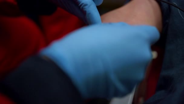 Cánula paramédica insertando aguja en el brazo. Trabajador colocando catéter IV en la vena — Vídeo de stock