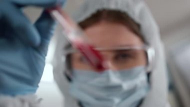 Bilim adamı tüpteki kan örneğini inceliyor. Tıbbi tanı koyan teknisyen 