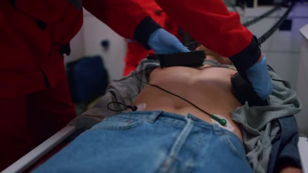 Zdravotníci ruce dělat cpr s defibrilátorem na člověka v nouzovém autě — Stock video