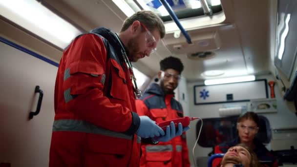 Les ambulanciers paramédicaux mixtes vérifient le niveau de saturation sanguine en oxygène du patient — Video