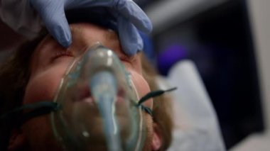 Paramedikler el feneriyle adamı kontrol ediyor. Doktor erkek hastayı muayene ediyor. 