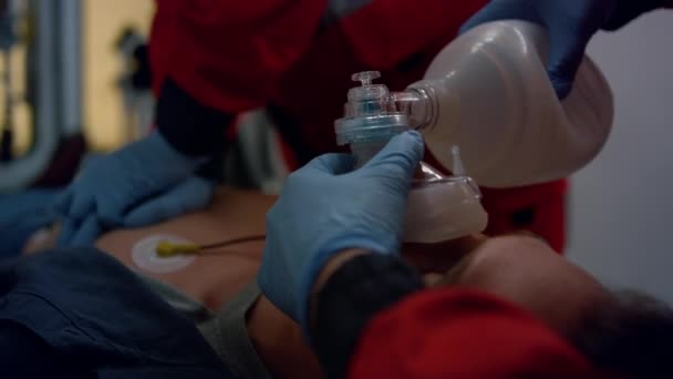 Mains paramédicales fournissant les premiers soins de l'homme avec masque respiratoire cardiaque — Video