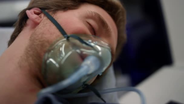 Eszméletlen ember oxigénmaszkban lélegzik. Hordágyon fekvő férfi beteg — Stock videók