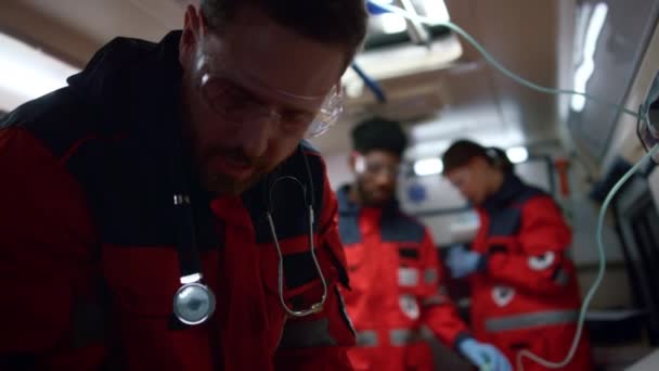 Doctor trabajando en un coche de emergencia. Los paramédicos del equipo se mueven para llamada de emergencia — Vídeos de Stock