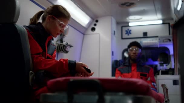 Sanitäter setzen Notruf im Rettungswagen ab — Stockvideo