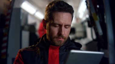 Paramedikler tablet üzerinde çalışıyor. İnternet 'te bilgi okuyan adam