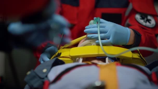 구급차에 타고 있는 부상당 한 환자를 응급 치료하는 구급 요원들 — 비디오