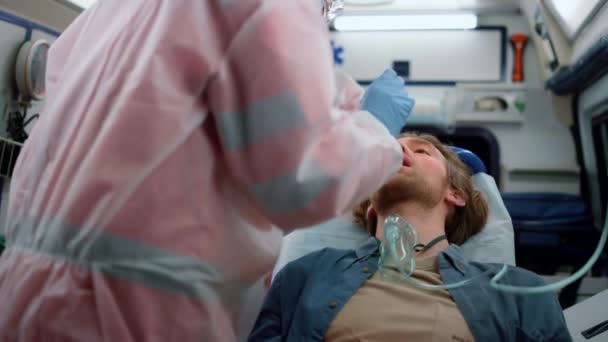 Médecins urgentistes qui prélèvent l'écouvillonnage nasopharmaceutique du patient pour un échantillon de coronavirus — Video