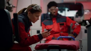 Ambulans aracıyla kaza yapan sağlık görevlileri. Doktor akıllı telefon kullanıyor.