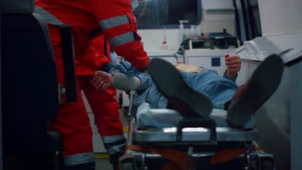 Paramédicos probando primeros auxilios al paciente. Los médicos que aplican el vendaje a la mano del hombre — Vídeos de Stock