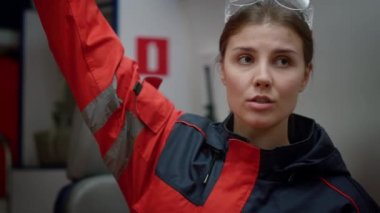 Doktor ambulans vagonunda oturuyor. Plastik bacak hareketsizleştirici tutan sağlık görevlisi.