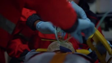 Acil servis doktorları adama zararsız havalandırma maskesi takıyor.