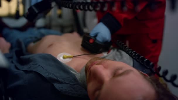 Az orvos külső defibrillátorral menti meg a beteget. Paramedikus újraélesztő férfi — Stock videók