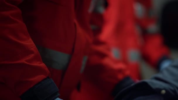 Equipo del servicio médico de emergencia que atiende al paciente masculino en el coche de emergencia — Vídeos de Stock