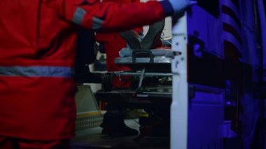 Sağlık görevlileri ambulansla birini naklediyor. Asistanlar hastayı hastaneye götürüyorlar.