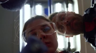 Çok ırklı sağlık görevlileri ambulans arabasında fenerle hastayı inceliyor.