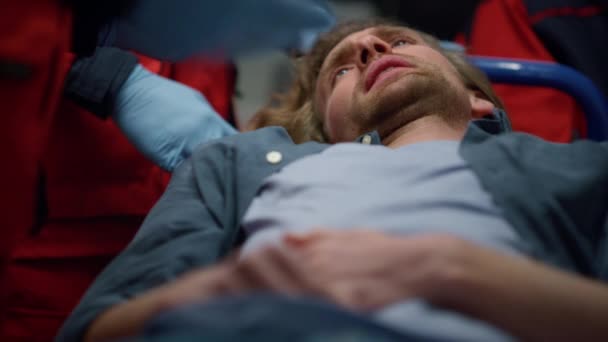 Człowiek leżący na noszach w samochodzie pierwszej pomocy. Mężczyzna odczuwa ból brzucha — Wideo stockowe