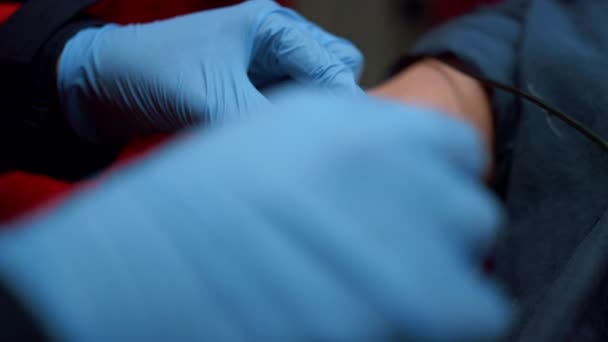 Medical worker in gloves inserting iv fluids into patient arm with catheter — Stock Video