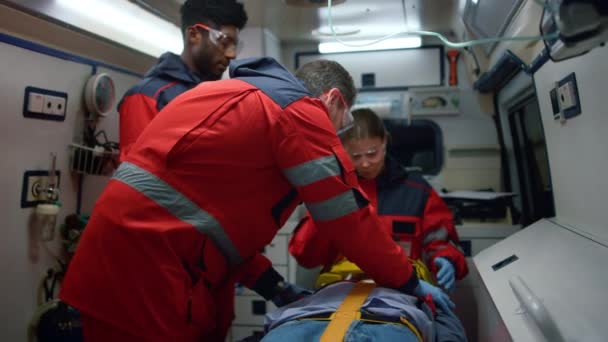 Los paramédicos resucitan al hombre en el coche. Personal médico salvando la vida del paciente — Vídeos de Stock