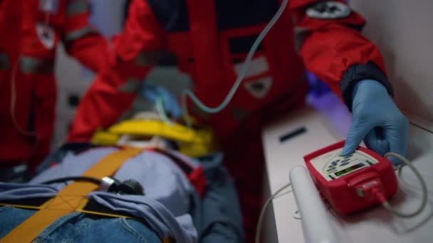 Les ambulanciers mains dans les gants fournissant des soins d'urgence du patient dans la voiture d'ambulance — Video