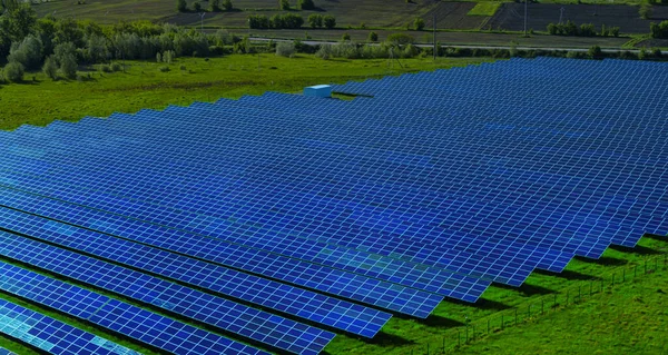 Luftaufnahme blauer Sonnenkollektoren auf dem Hintergrund der Natur. Konzept für erneuerbare Energien. — Stockfoto